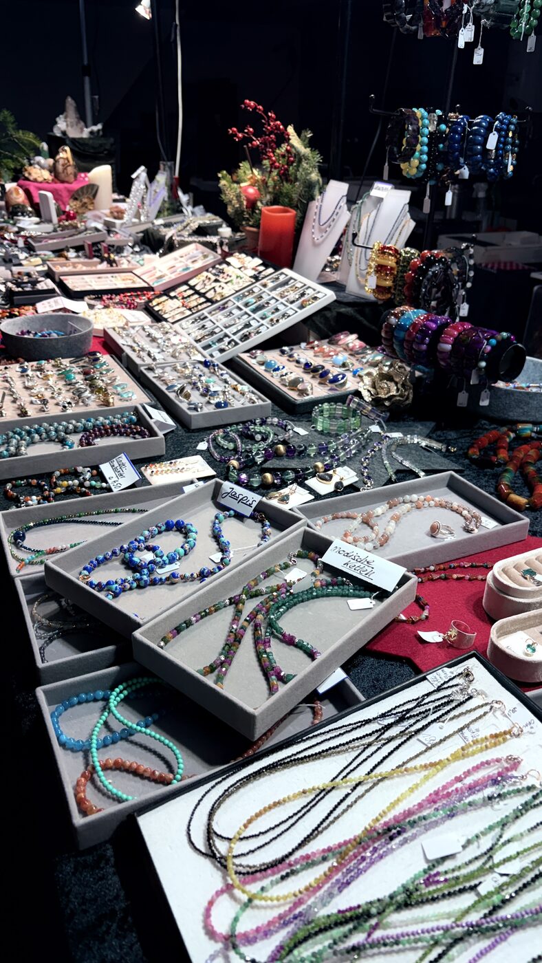 Schmuckstand mit bunten Ketten, Armbändern und Ringen