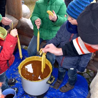 Kinder beim Kerzenziehen beim Weihnachtsmarkt Illingen